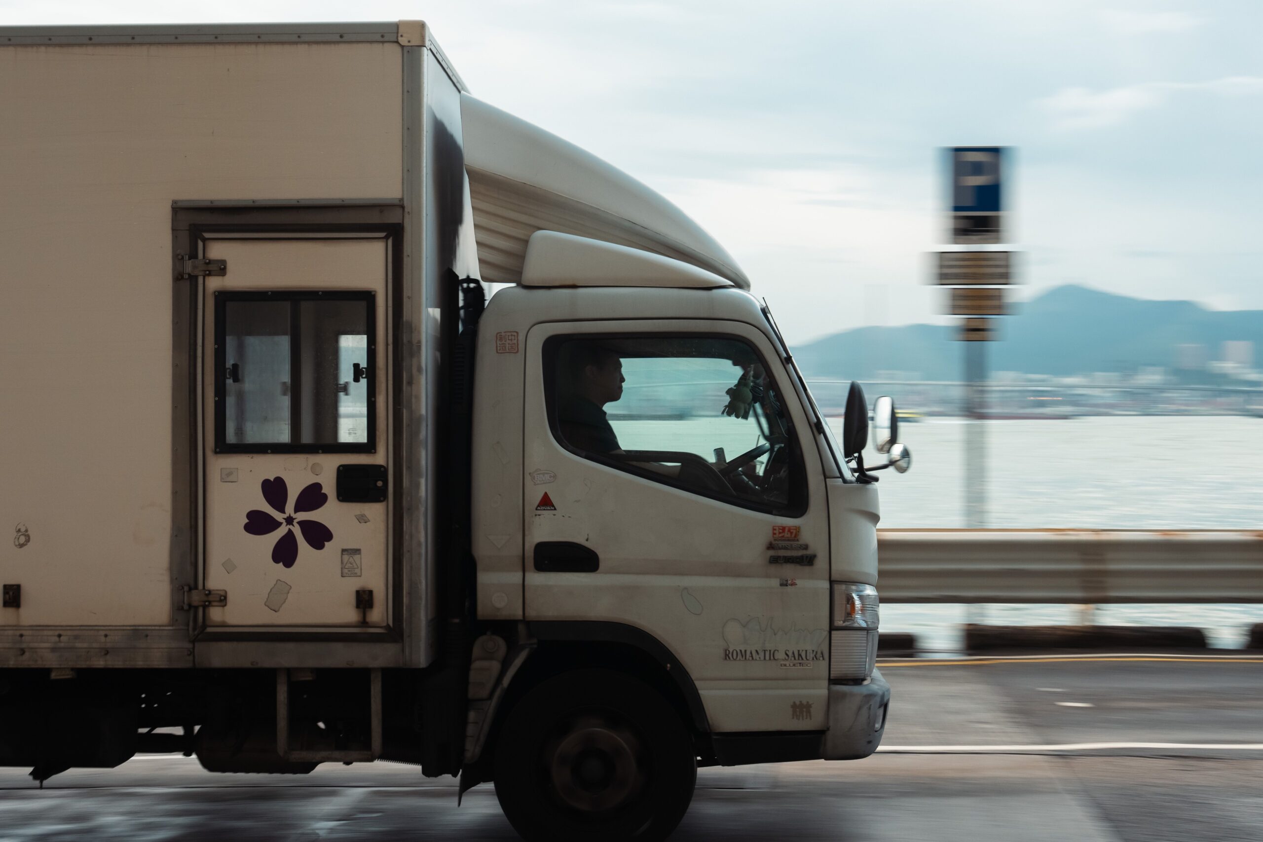 A white truck driving on a road, illustrating vehicles permissible under a standard car license.